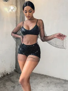 Detailed view of a stunning black long-sleeve rhinestone fishnet dress on a model