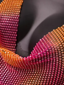 Primer plano de pedrería brillante en un chaleco halter de malla de colores.