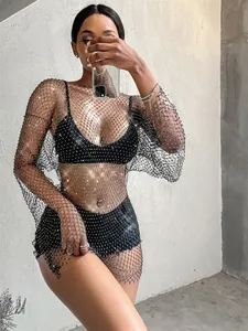 Close-up detail of a glamorous black sparkly rhinestone mesh long sleeve dress