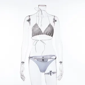 Detailed view of sexy two-piece bikini set with sparkly silver top and white bottoms
