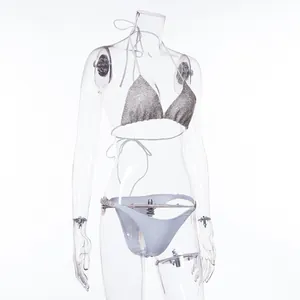 Detailed view of a sparkly silver triangle bikini top and white bottoms on a mannequin