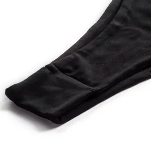 Detailed macro view of the black elastic fabric and hem on a solid color split swimsuit