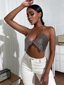 Detailed view of model wearing a sparkly silver rhinestone halter top with backless design