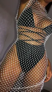 Close-up detail of a white rhinestone fishnet dress featuring sparkling crystal accents