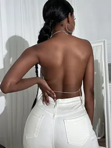 Detailed back view of a sparkling rhinestone backless chain top on a female model.