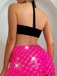 Detailansicht der Rückseite eines pinkfarbenen Pailletten-Minirocks mit schwarzem Crop-Top