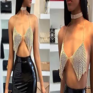 Close-up of a sparkling gold rhinestone halter top worn by a model in a luxury setting