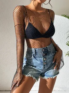 Detailaufnahme eines schwarzen Netzoberteils mit Strasssteinen und Jeans-Shorts kombiniert