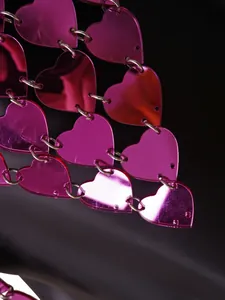 Detailaufnahme einer rosa Herz-Acryl-Kettenweste mit glänzendem, reflektierendem Finish
