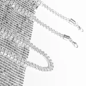 Macro detail of silver metallic mesh dress with shimmering rhinestone chain straps
