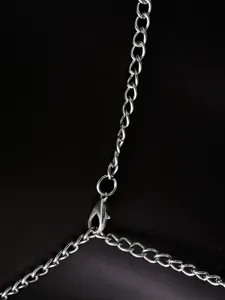 Detailaufnahme von silbernem Karabinerverschluss und verstellbarer Kette am rückenfreien Top