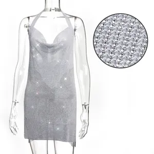 Gros plan sur une mini-robe dos nu scintillante en strass argentés avec détails.