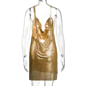Dettaglio dell'abito corto in maglia metallica dorata con elegante scollo a cappuccio