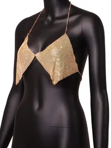 Detail view of a glamorous gold rhinestone mesh halter top displayed on a black mannequin