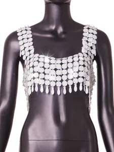 Gros plan d'un haut à paillettes blanches avec des détails brillants et pompons.