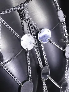 Detailed macro view of sexy silver mirror acrylic pieces and chain body harness