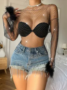 Detail of black fishnet long sleeve top featuring intricate shimmering rhinestone embellishments