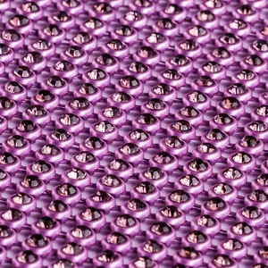 Détail macro d'un tissu en maille de strass violets chatoyants pour robes.