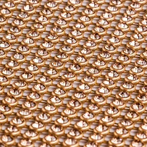 Gros plan macro d'un tissu en résille de strass étincelants avec grille métallique dorée