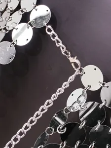 Gros plan d'un haut à paillettes argentées sexy avec fermoir mousqueton et chaînette