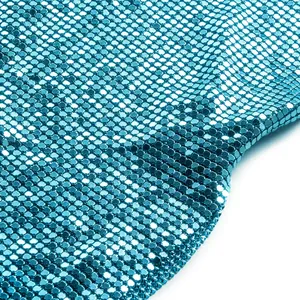 Dettaglio ravvicinato del tessuto a paillettes blu scintillanti di un'elegante gonna midi.
