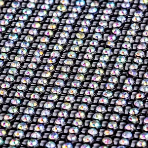 Détail macro de strass AB irisés fixés sur une robe de soirée sexy en tissu de mesh noir