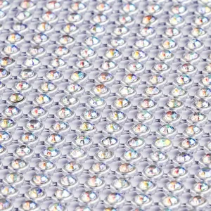 Vue macro détaillée montrant la texture en maille strass étincelante de la robe de soirée