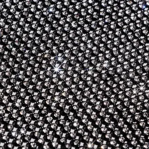 Macro detail of sparkling rhinestones on black mesh nightclub fashion top for women