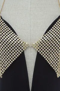 Close-up detail of the sparkling rhinestone mesh and deep V-neckline on a sexy nightclub top.