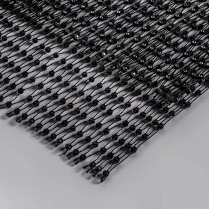 Close-up detail of black mesh dress fabric with sparkling rhinestone embellishments