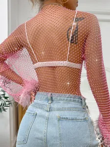 Close-up of pink fishnet long-sleeve top with shimmering rhinestone details