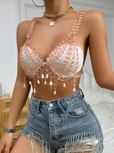 Detailed view of pink gemstone beads and pearl drops on a white chic bralette top