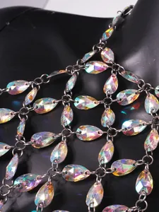 Dettaglio macro dei cristalli a goccia iridescenti su un top sexy con catena e scollo all'Halter