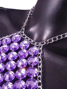 Primo piano del dettaglio del cristallo sfaccettato viola e della maglia a catena argentata.
