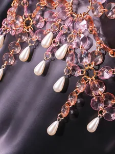 Close-up detail of elegant pink crystal and teardrop pearl chain straps on a tube top