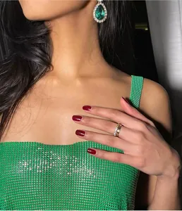 Detailed macro view of a vibrant green sequin metal mesh camisole top featuring thin straps.