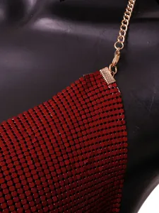 Close-up detail of red metal sequin halter top with golden chain strap and clasp.