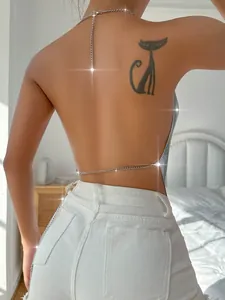 Dettaglio ravvicinato di un top sexy con paillettes argento e catena in metallo.