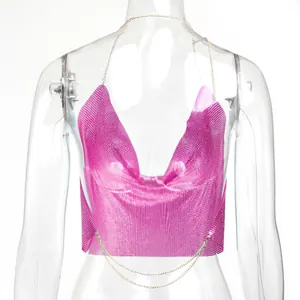 Dettaglio di un top allacciato al collo con paillettes metalliche rosa acceso su manichino.