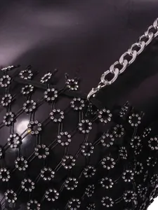 Close-up of black mesh dress with rhinestone plum blossom and chunky silver chain.