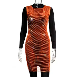 Macro detail of vibrant orange mesh dress featuring intricate sparkling rhinestone decorations