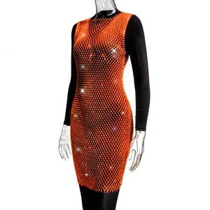 Detail of orange mesh dress with sparkly rhinestones over black long-sleeve top
