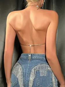Detail of gold rhinestone chain backless halter top with glittering fringe shorts