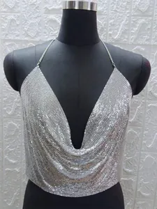 Dettaglio del sexy top allacciato al collo con paillettes metalliche argento su manichino