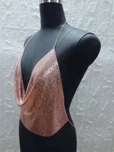 Vista laterale che mostra le paillettes metalliche di un top all'americana oro rosa sul busto.