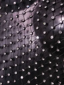 Nahaufnahme von schwarzem Netzstoff mit glitzernden Strasssteinen für sexy Taillenweste