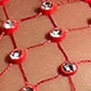 Close-up of red fishnet mesh fabric with sparkling rhinestone crystal embellishments