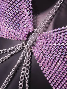 Detaillierte Nahaufnahme des lila Strass-Mesh-Tops mit silbernen Ketten-Akzenten.