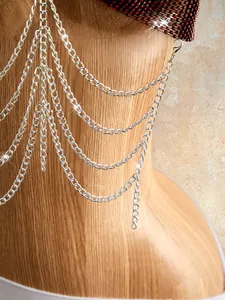Detail of burgundy rhinestone mesh bra with multi-layer silver fringe body chain.