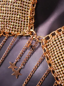Close-up detail of luxury gold rhinestone chainmail halter top with dangling star charms.